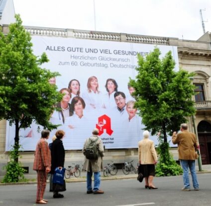 Größte Glückwunschkarte zum 60. der Bundesrepublik hängt in Berlin / Apotheker gratulieren: Gesundheit hat viele Gesichter